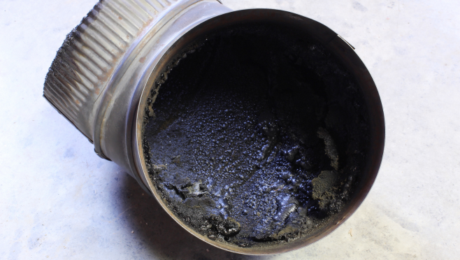 Flue pipe coated in creosote before a chimney cleaning