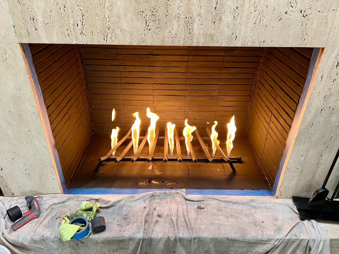 Gas fireplace burner lit during a repair job