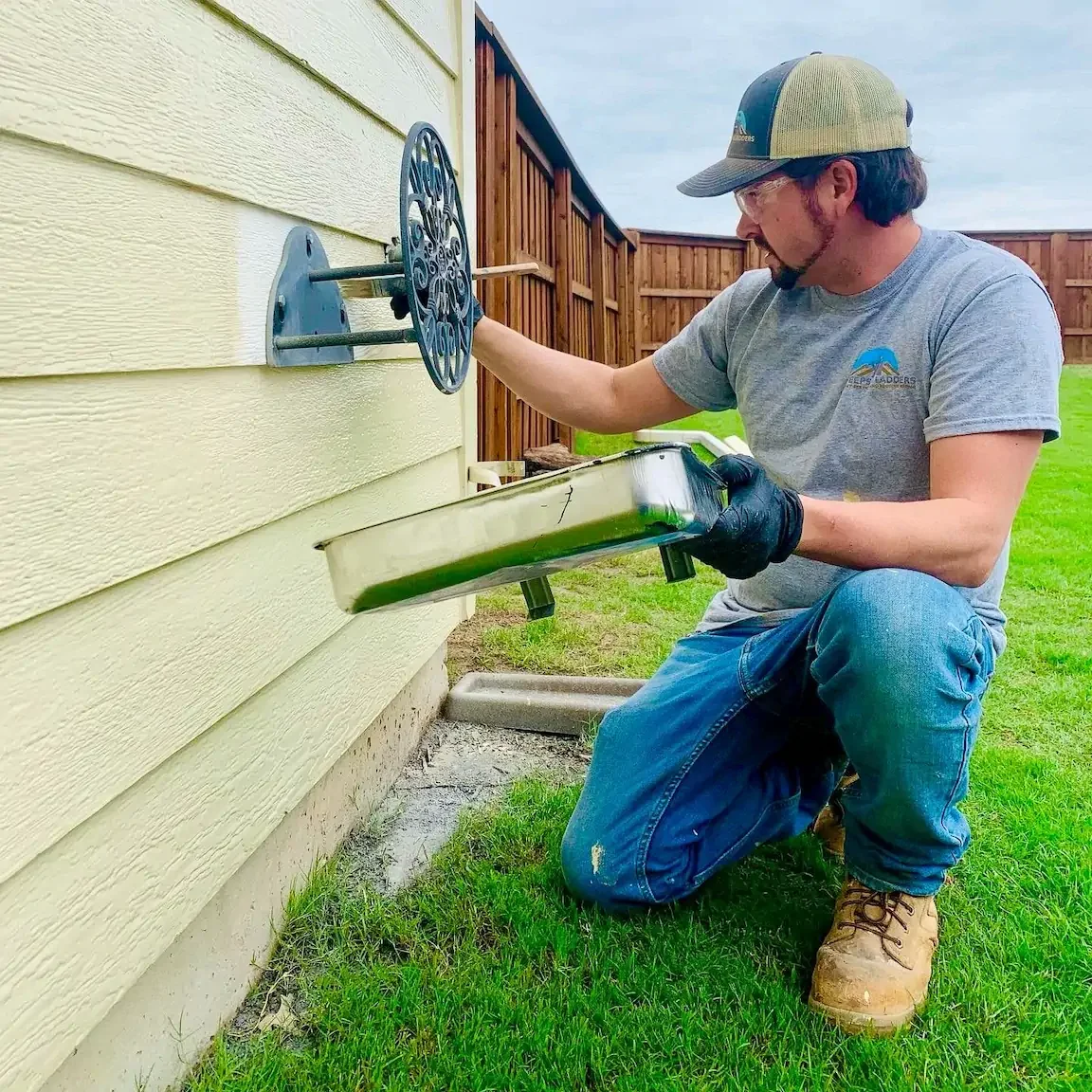 Technician cleaning a dryer vent from the exterior wall access point