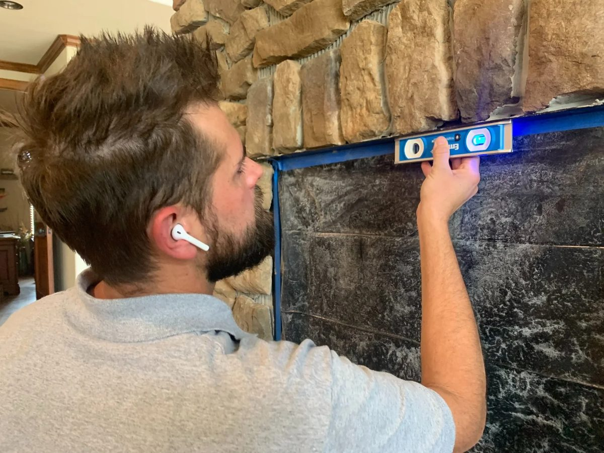 Technician leveling a fireplace surround