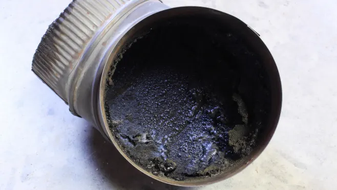 Flue pipe coated in creosote before a chimney cleaning