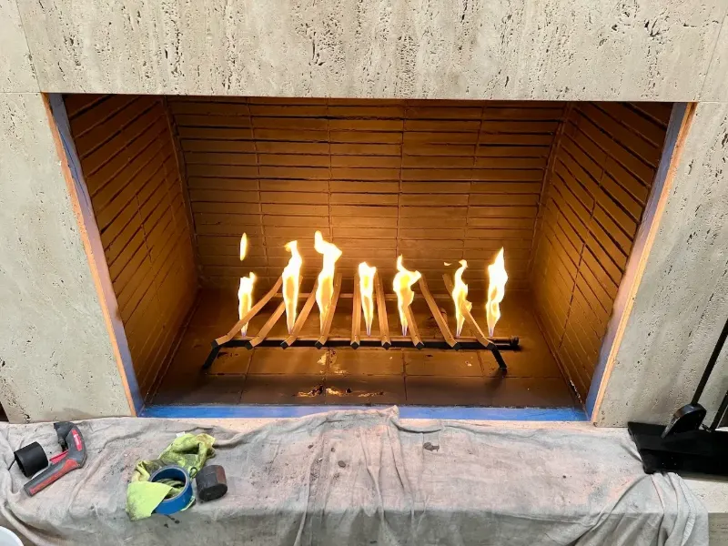 Gas fireplace burner lit during a repair job